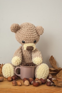 A cozy corner with a knitted throw, a steaming cup of tea, and a small butterscotch bear figurine