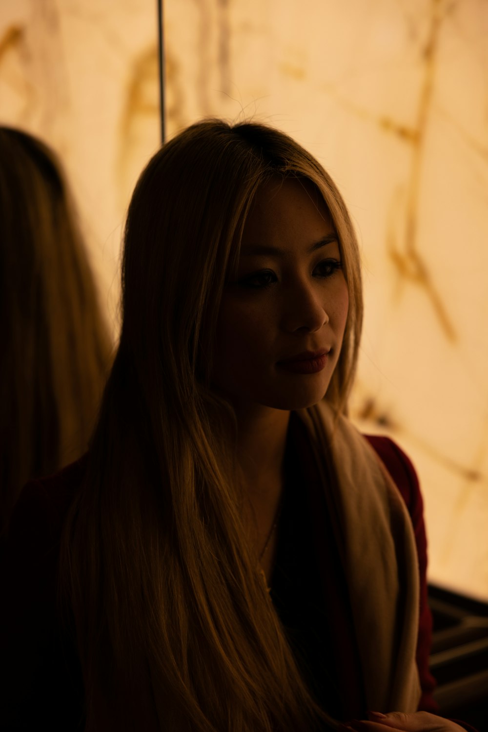 a woman with long blonde hair sitting down