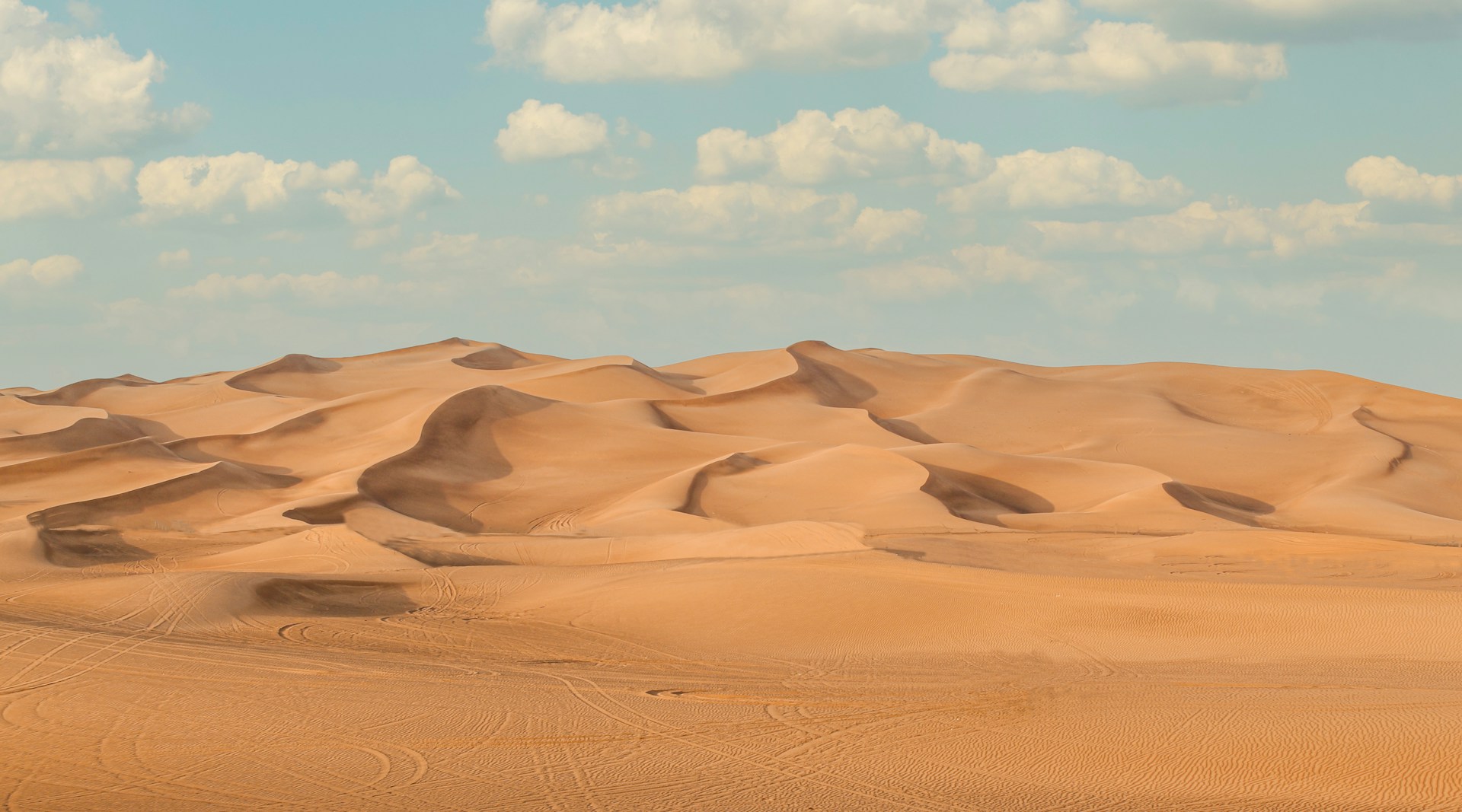 a large group of sand dunes under a blue sky