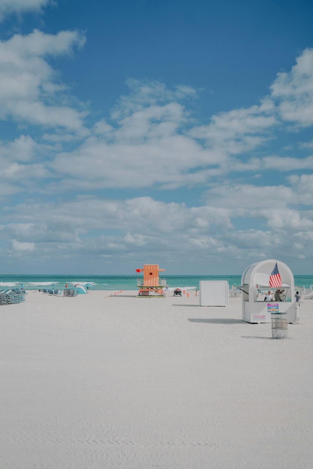 una playa con una carpa blanca y una bandera