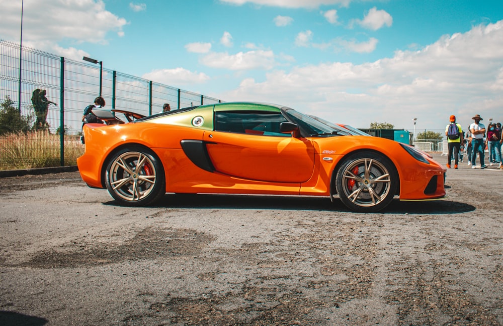 an orange sports car parked in a parking lot