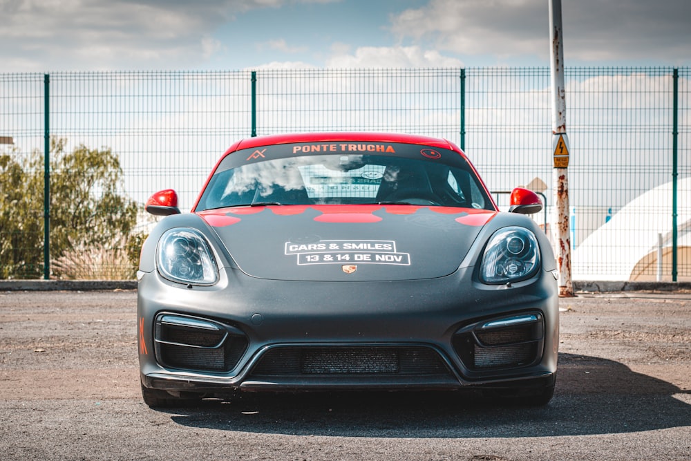 a grey and red sports car parked in a parking lot