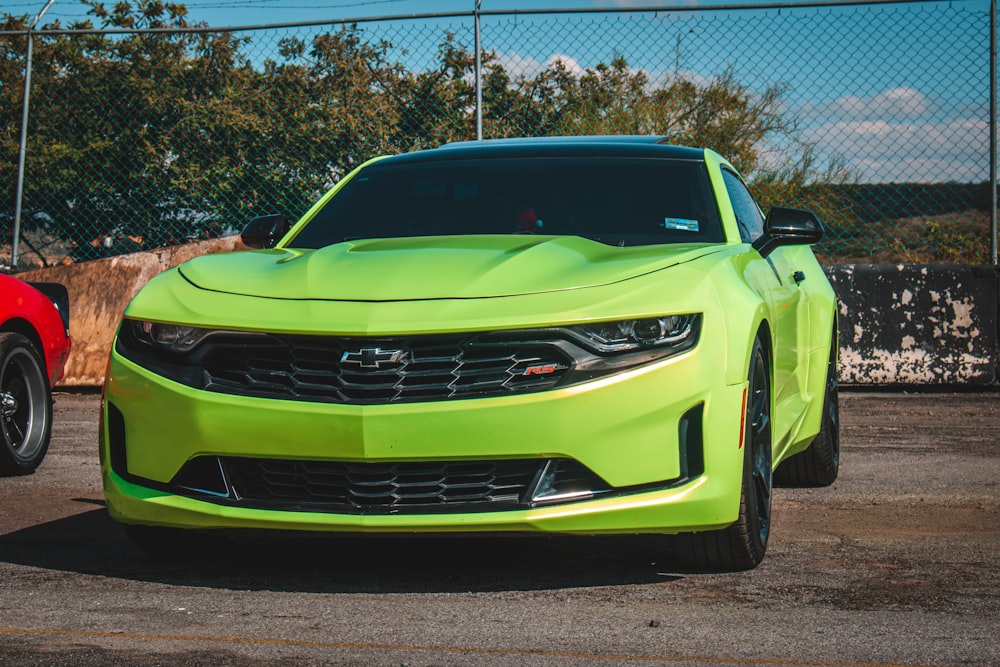 a bright green car parked next to a red car