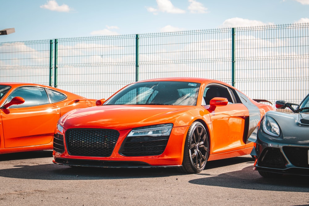 two orange sports cars parked next to each other