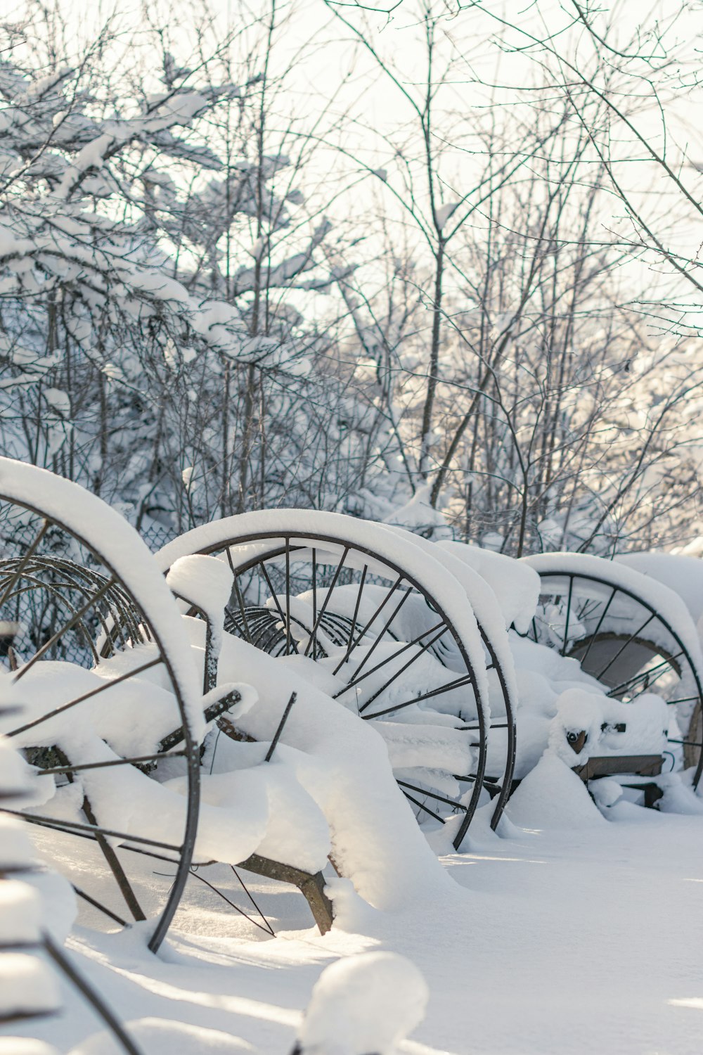 a row of snow covered wooden wagon wheels