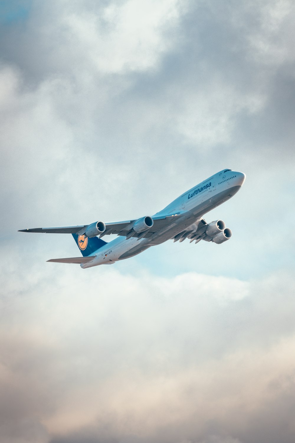 a large jetliner flying through a cloudy sky