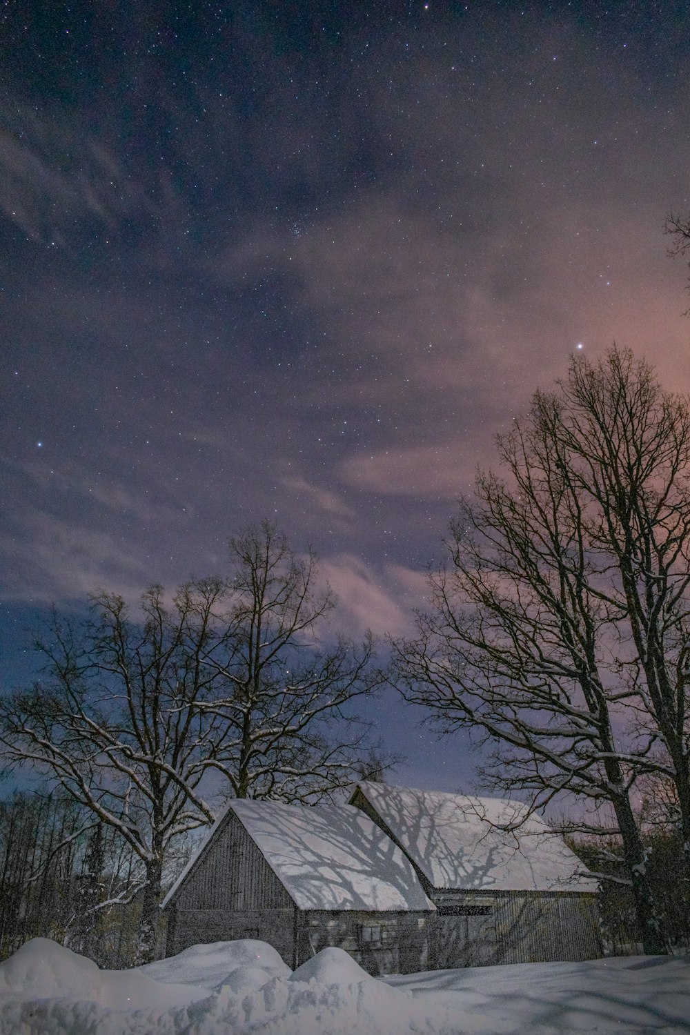 a house in the middle of a snowy field