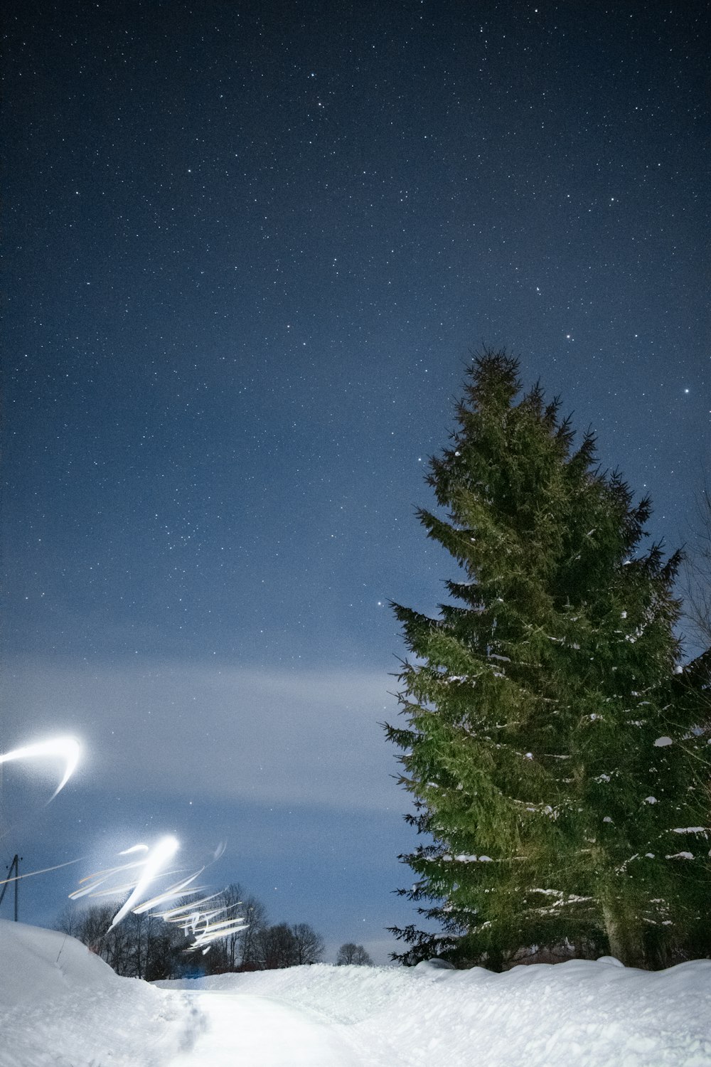 a snowboarder is going down a snowy hill at night