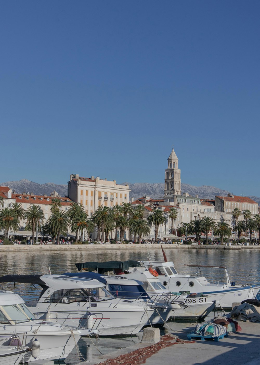 several boats are docked in a harbor with a city in the background