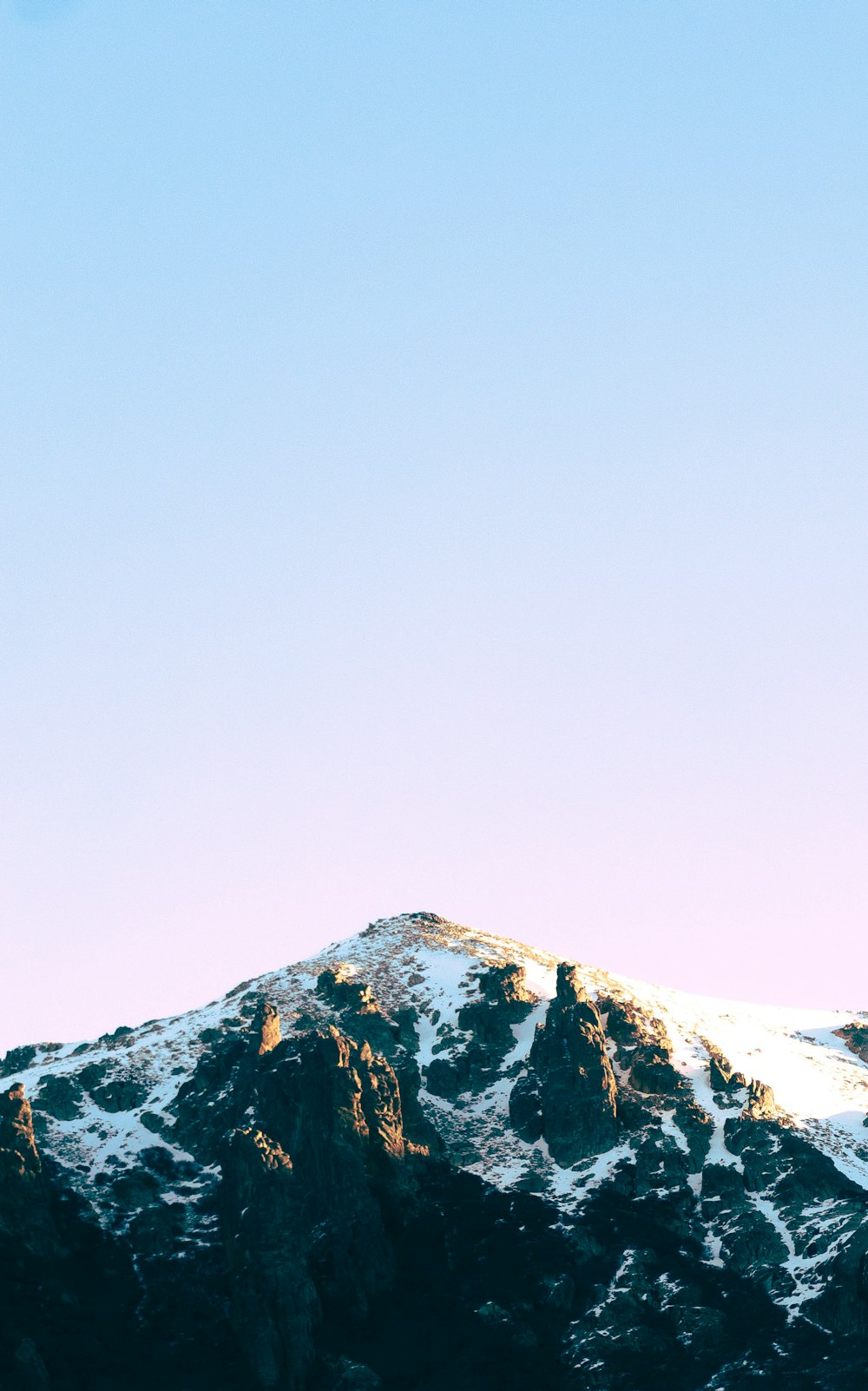 a snow covered mountain under a blue sky