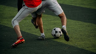 two men are playing soccer on a field