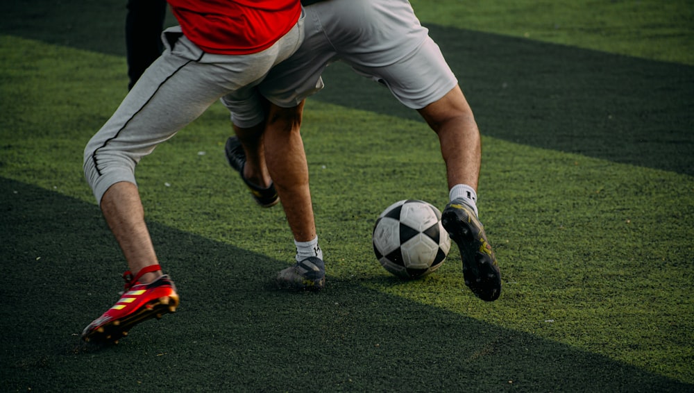 two men are playing soccer on a field