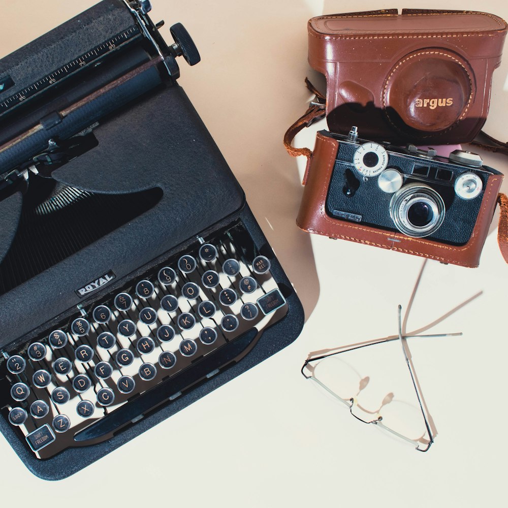 an old fashioned typewriter sitting next to a pair of glasses