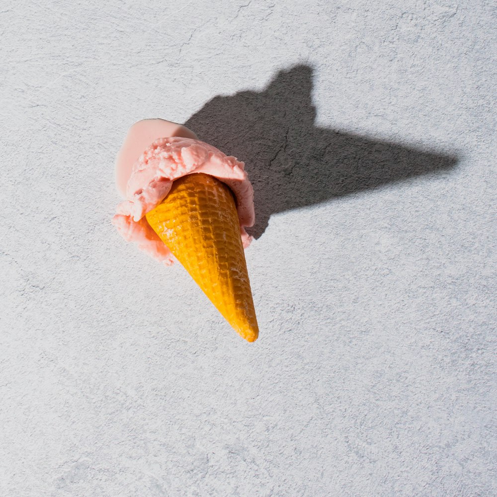 an ice cream cone is casting a shadow on the ground