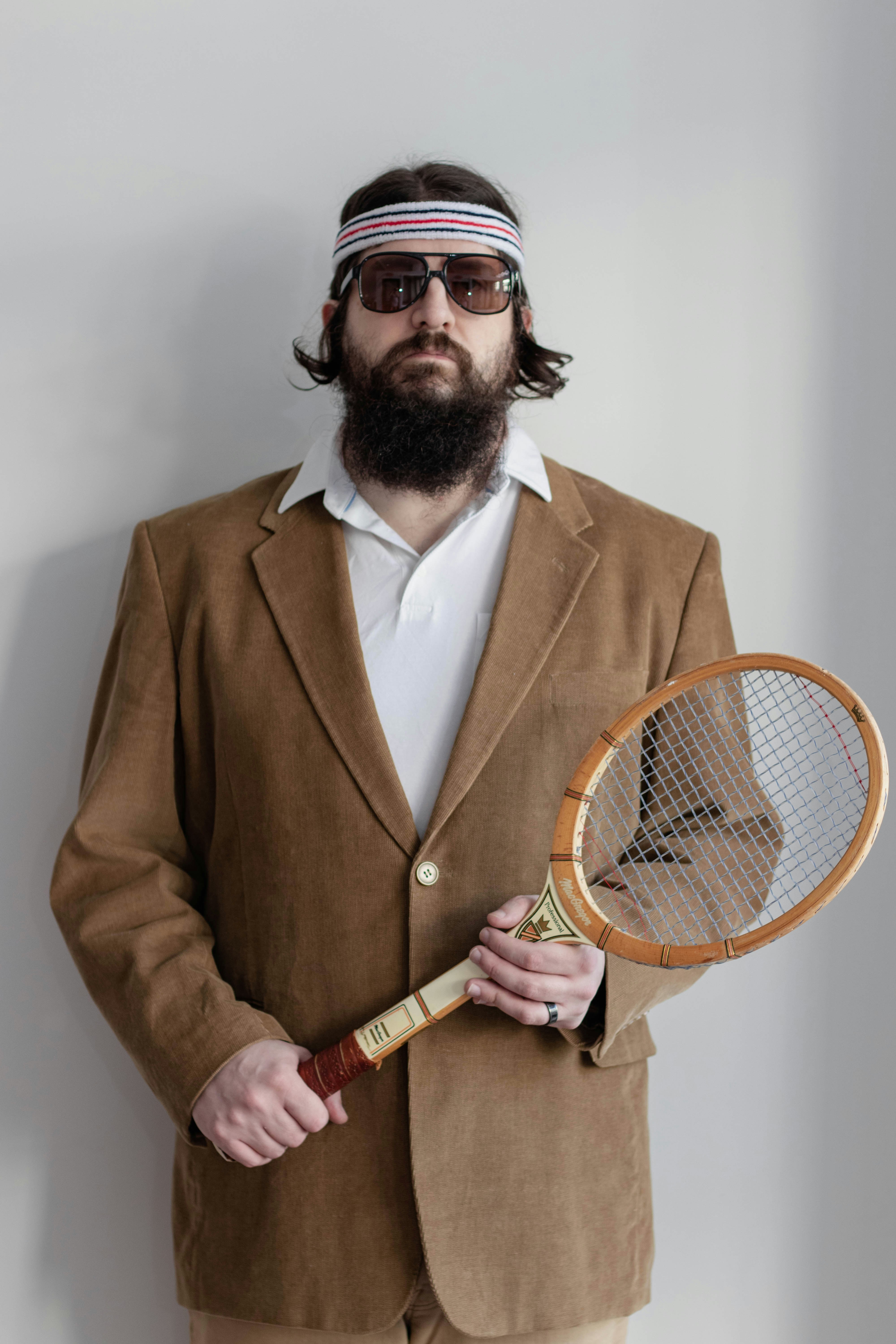 Ein Mann mit Bart, der einen Tennisschläger hält