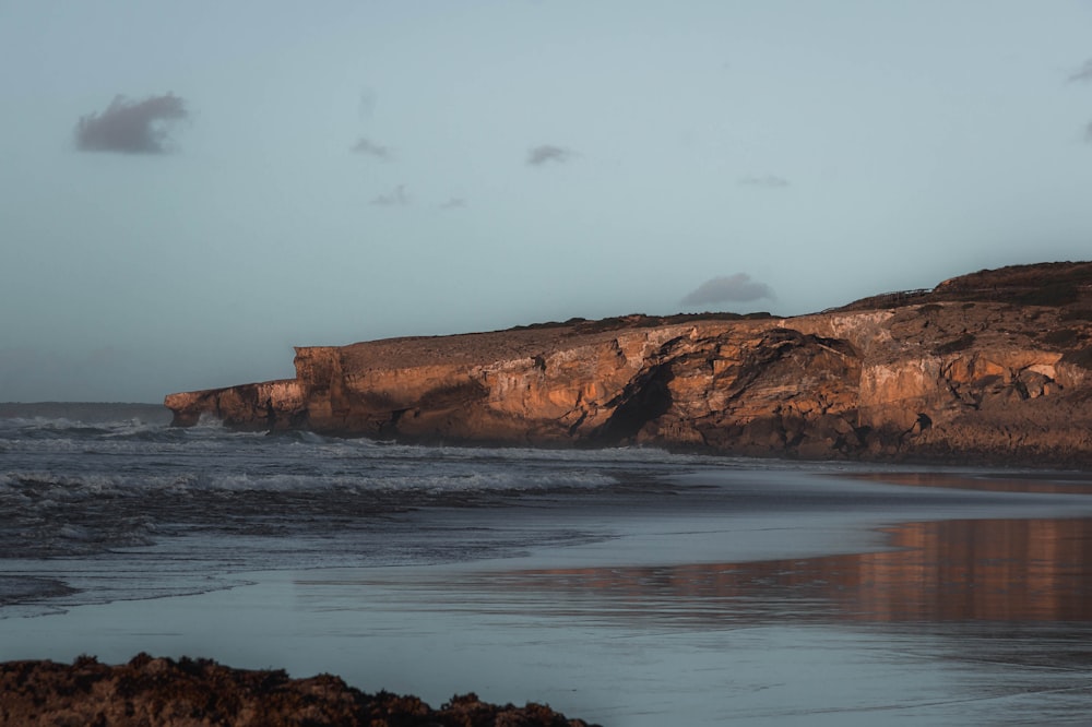 a rocky beach with waves coming in to shore