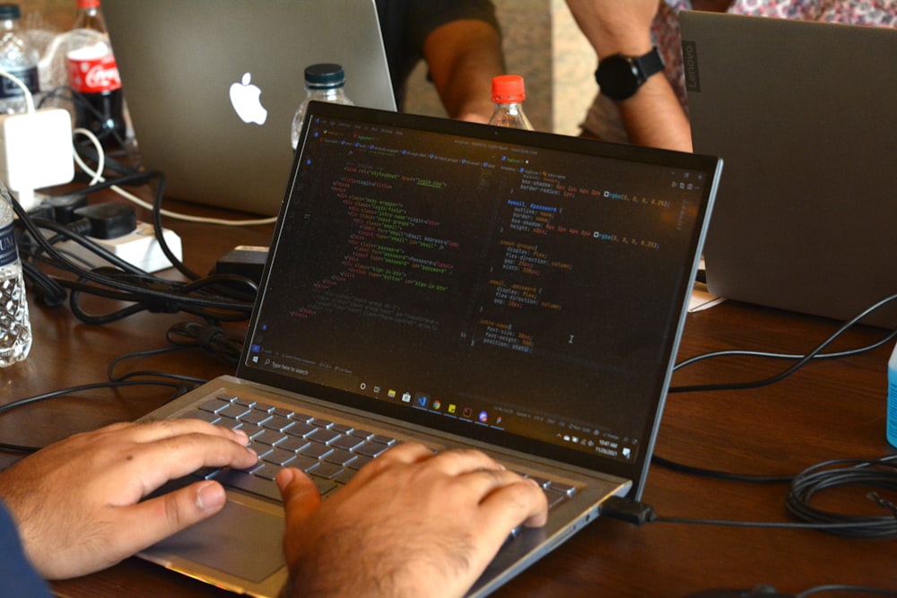 a man using a laptop computer on a wooden table