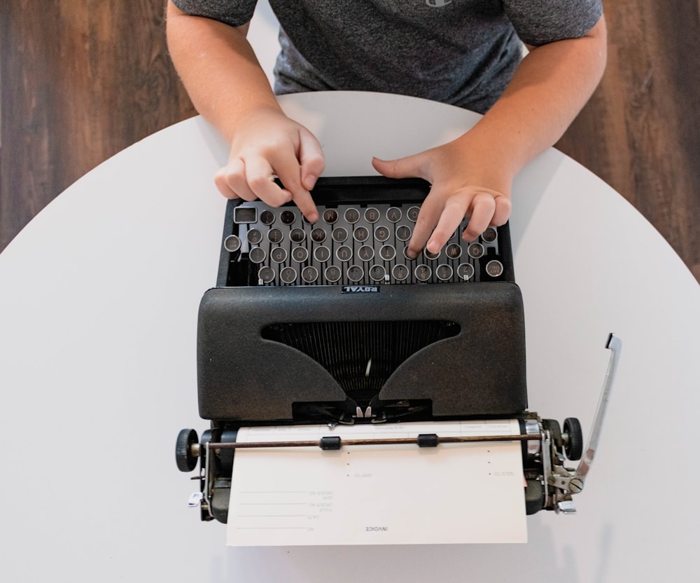 a person typing on an old fashioned typewriter