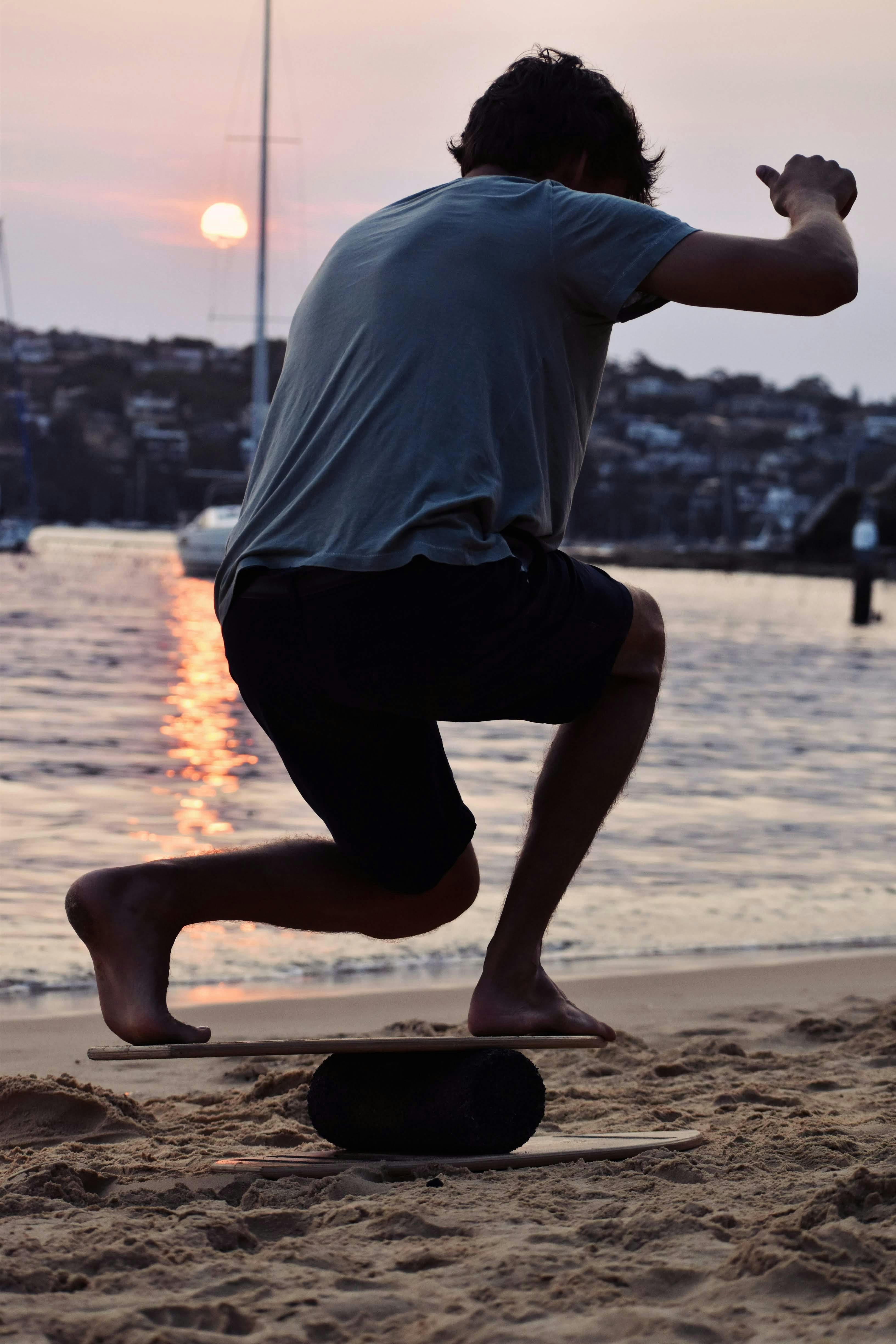 a man is running on a skateboard on the beach