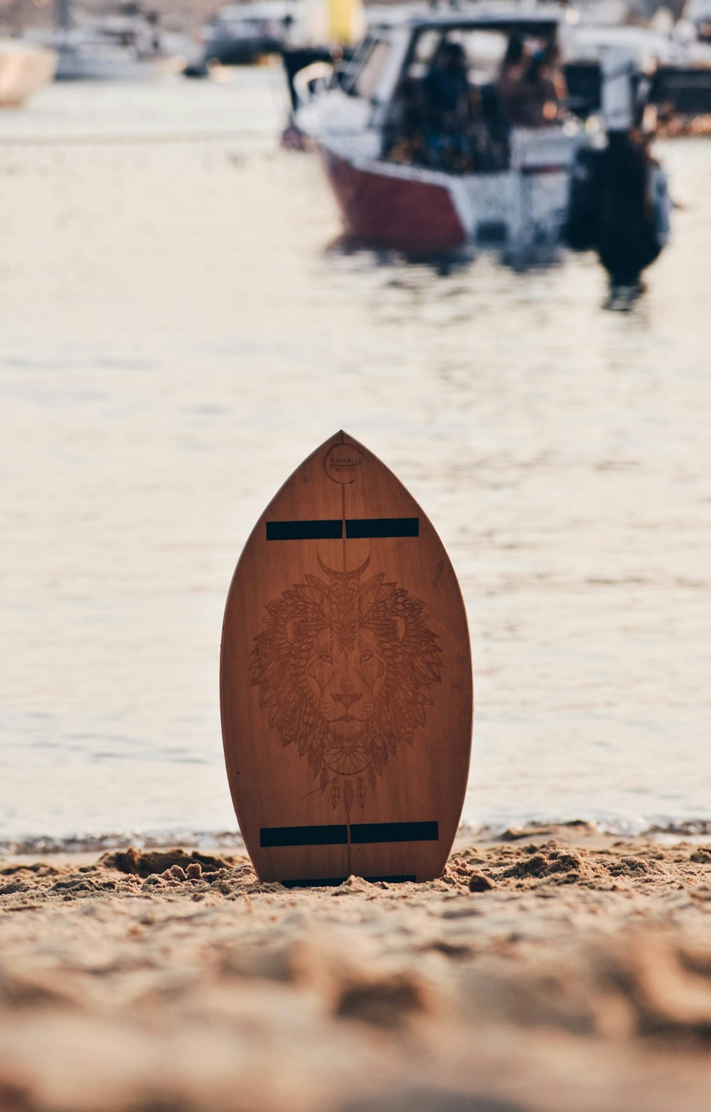 a brown surfboard sitting on top of a sandy beach