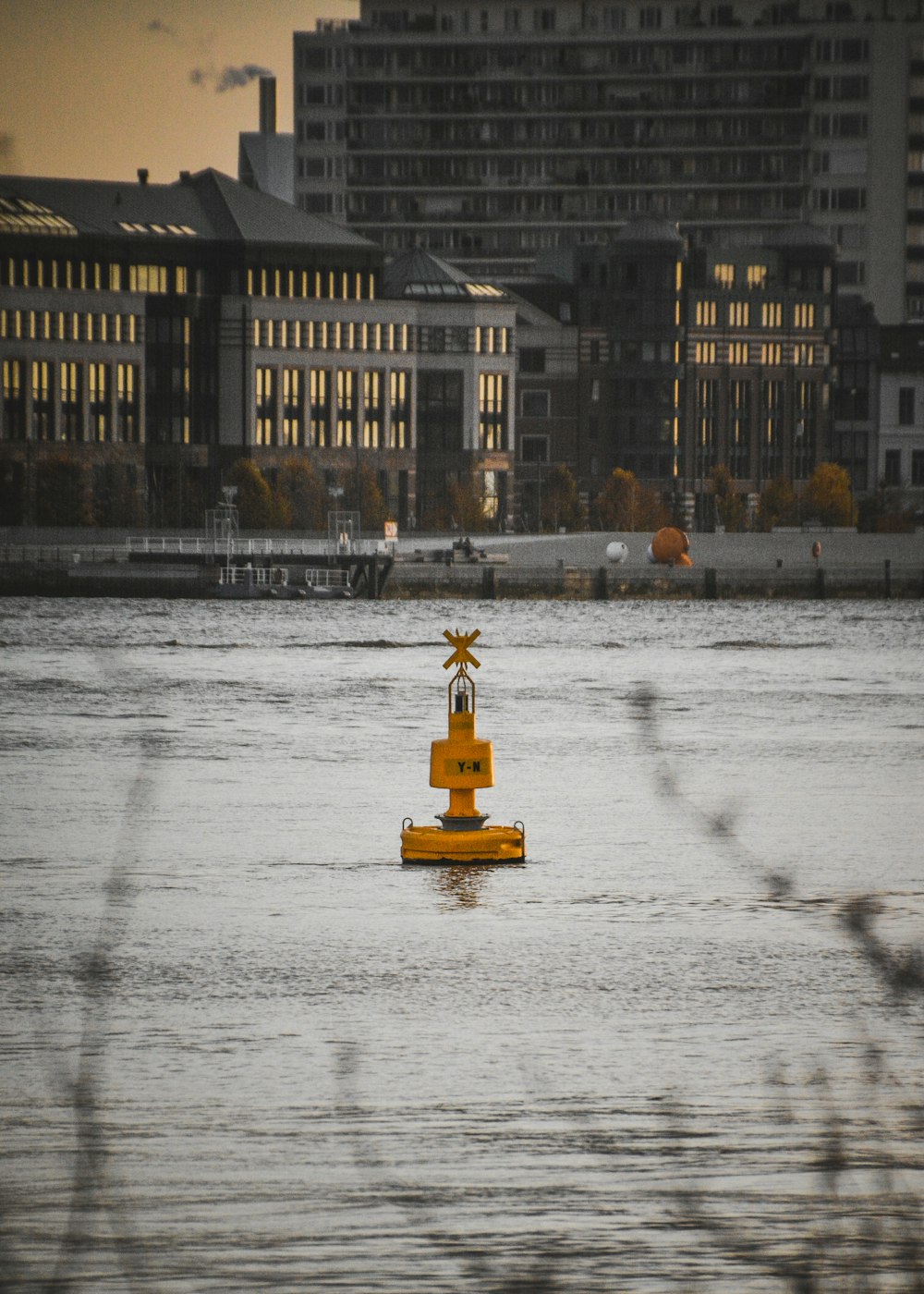 a yellow buoy floating in the middle of a body of water