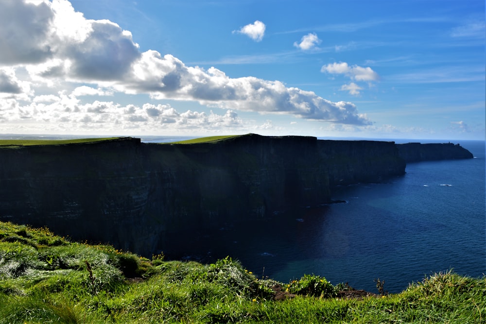 a cliff overlooking the ocean on a sunny day