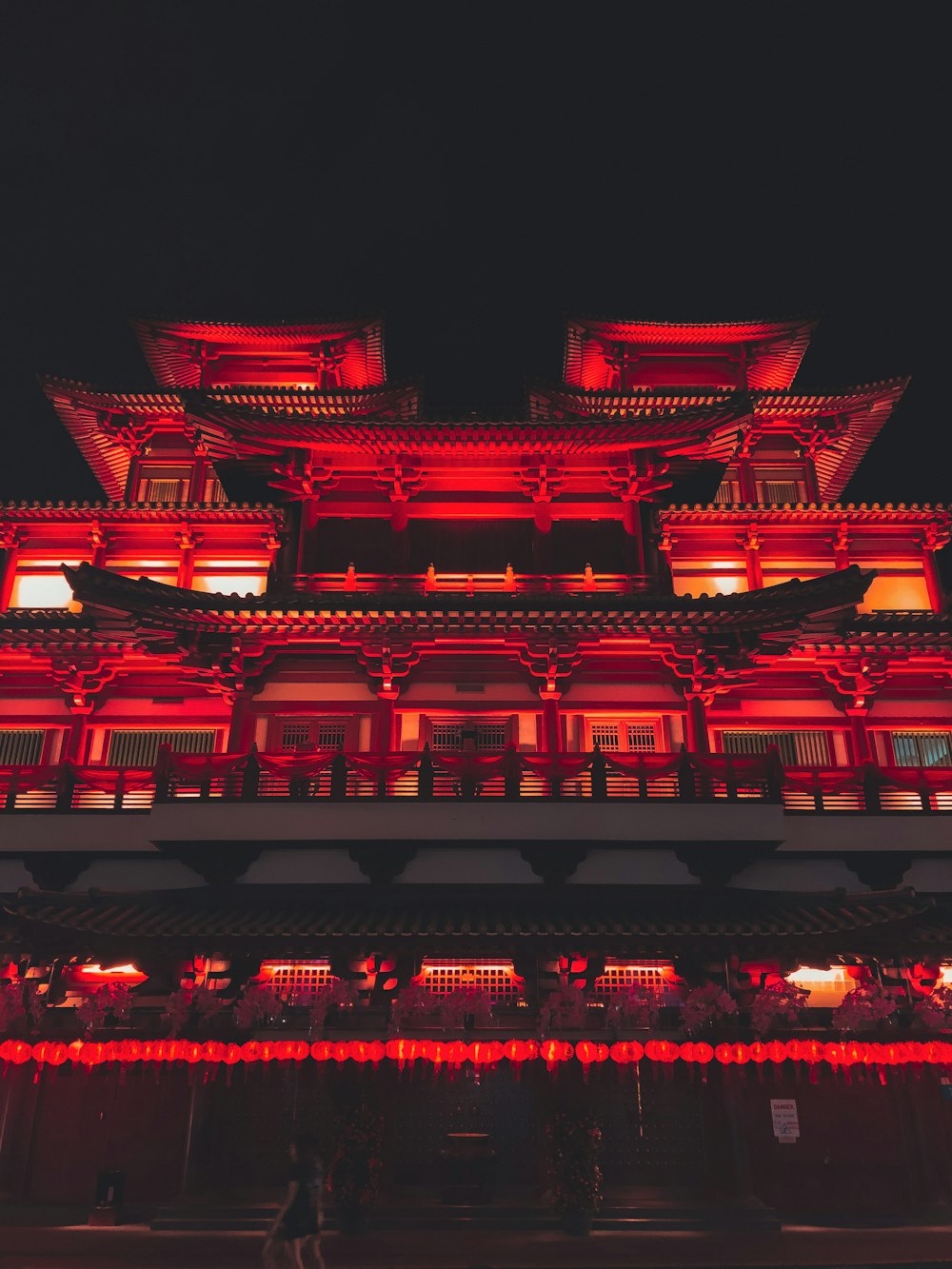 a tall building with red lights on top of it