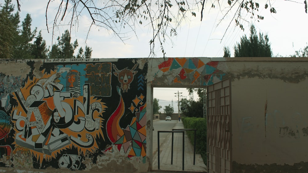 a wall covered in graffiti next to a gate