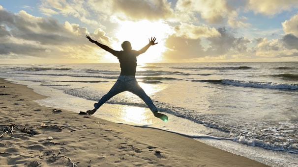 A joyful traveler enjoying a breathtaking sunset over a luxury beach resort.
