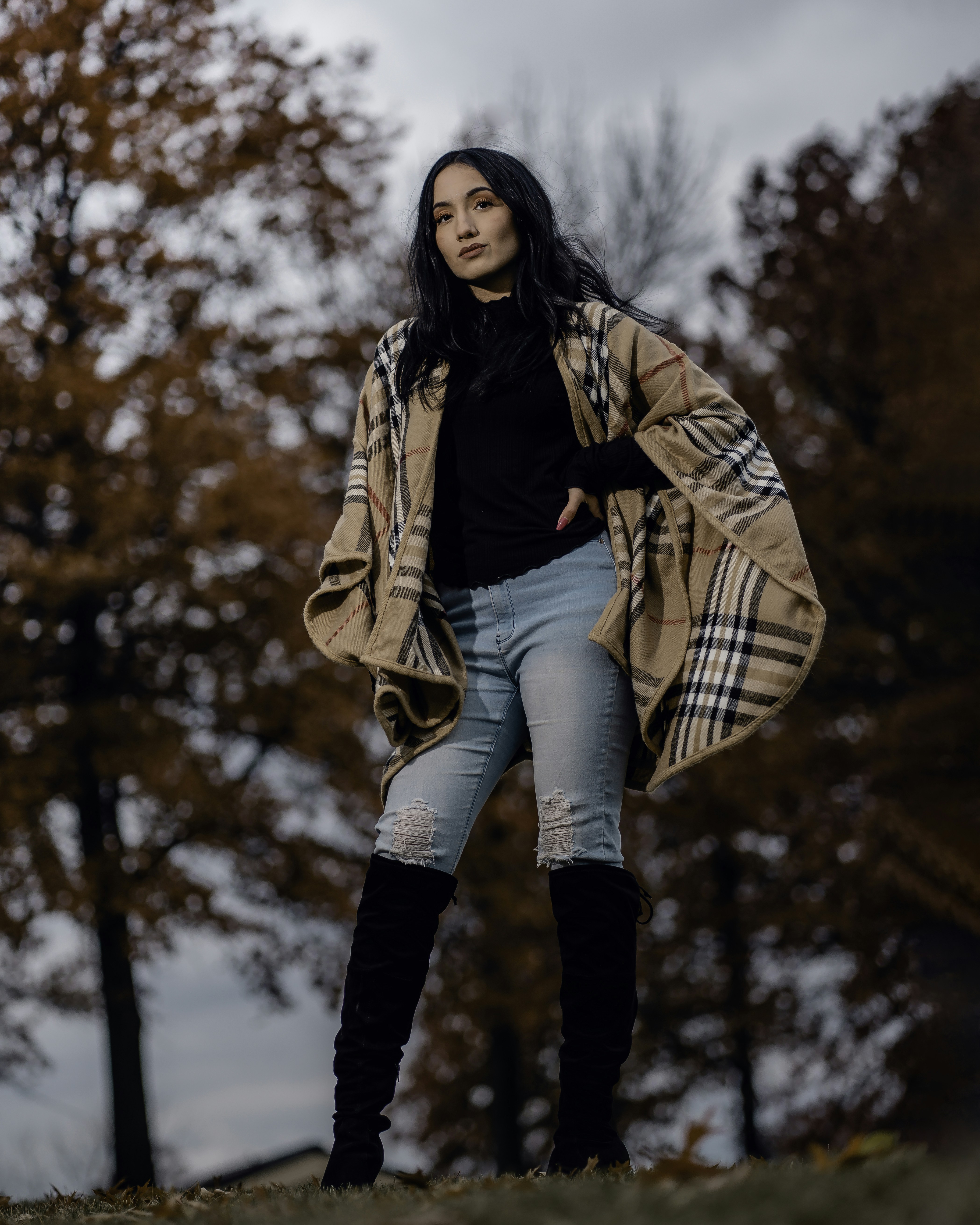 Una mujer parada en un campo con árboles en el fondo