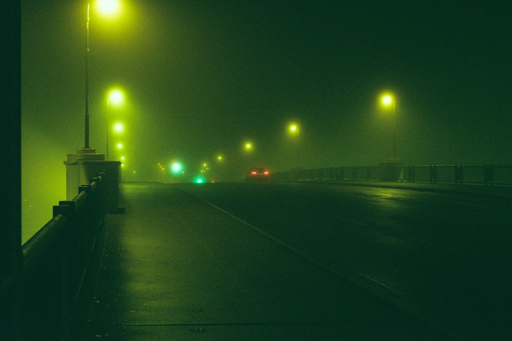 a foggy night on a city street with street lights