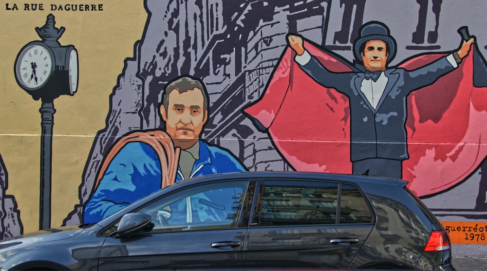 a car parked in front of a wall with a painting of a man and a