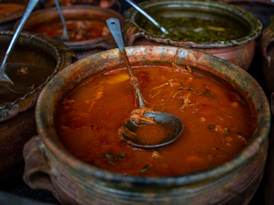Close-up of a traditional African vegetable stew simmering in a clay pot.