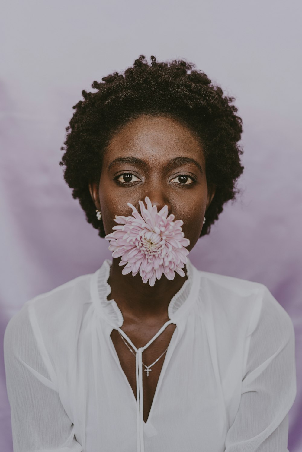 a woman with a flower in her mouth