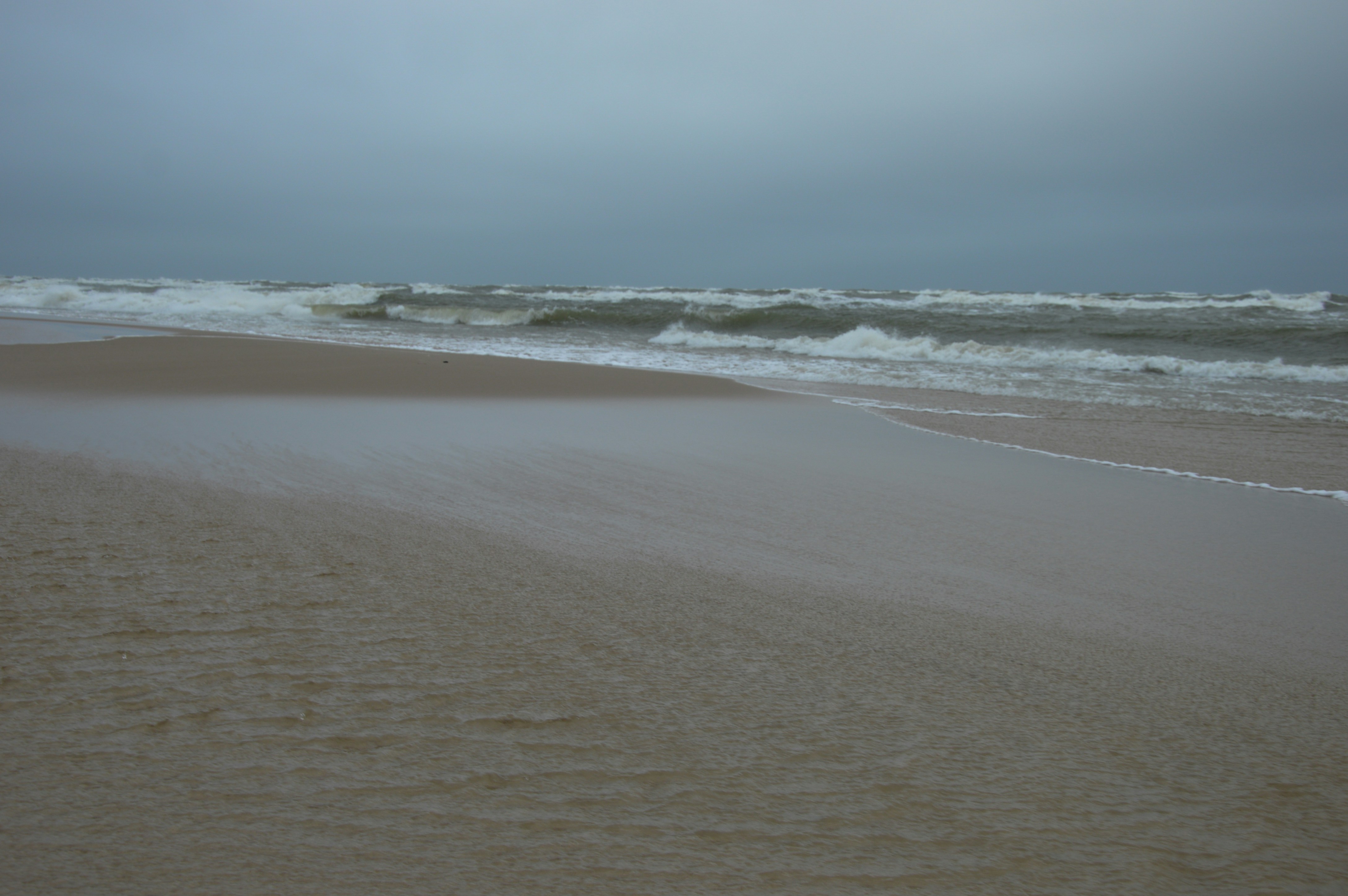 ein Sandstrand mit Wellen, die ans Ufer kommen