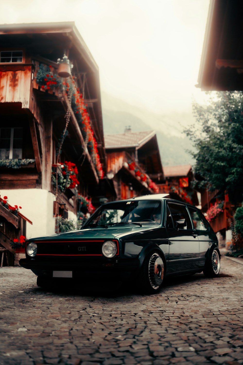 a black car parked on a cobblestone street