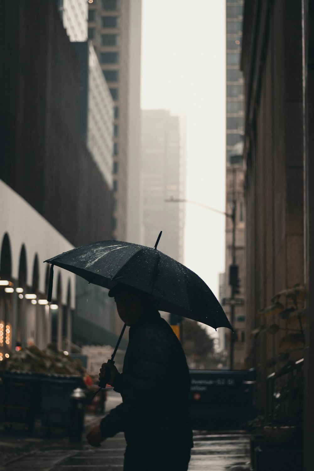 a woman walking down a street holding an umbrella