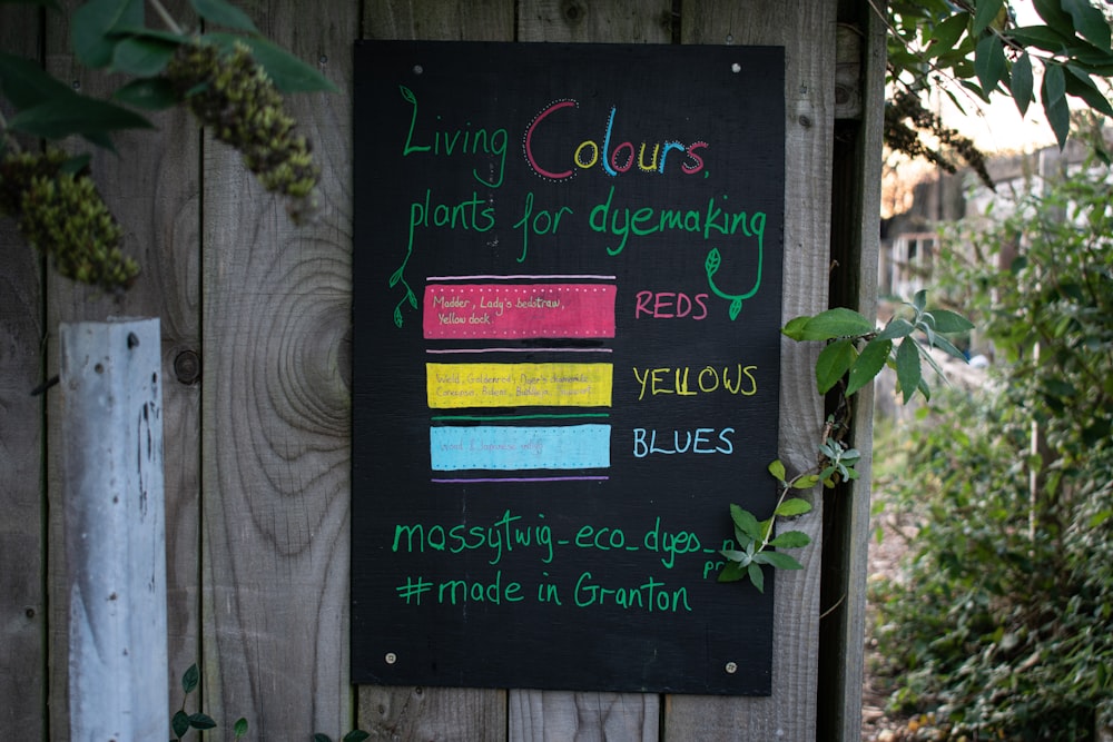 a sign on a wooden fence that says living colours