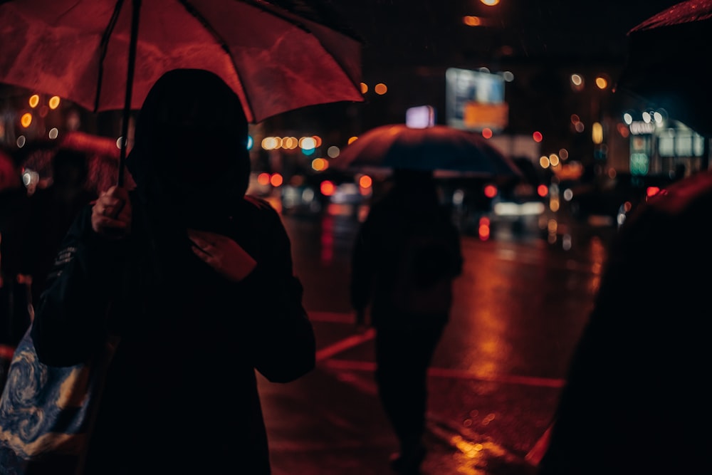 a group of people walking down a street holding umbrellas