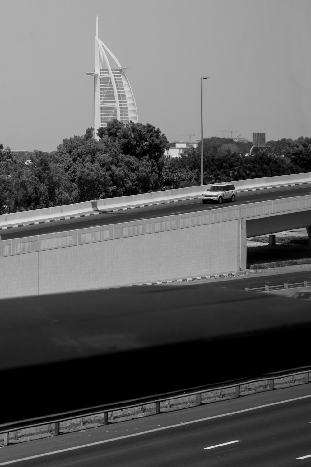 a black and white photo of a highway and a bridge