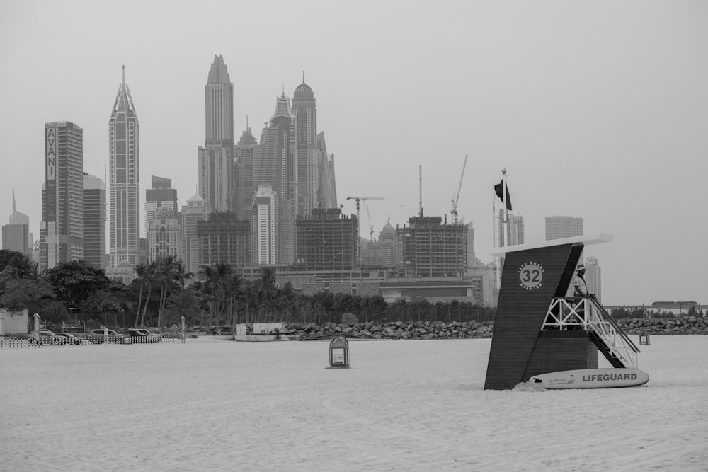 a black and white photo of a beach with a city in the background