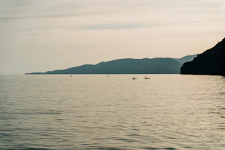 a large body of water with mountains in the background