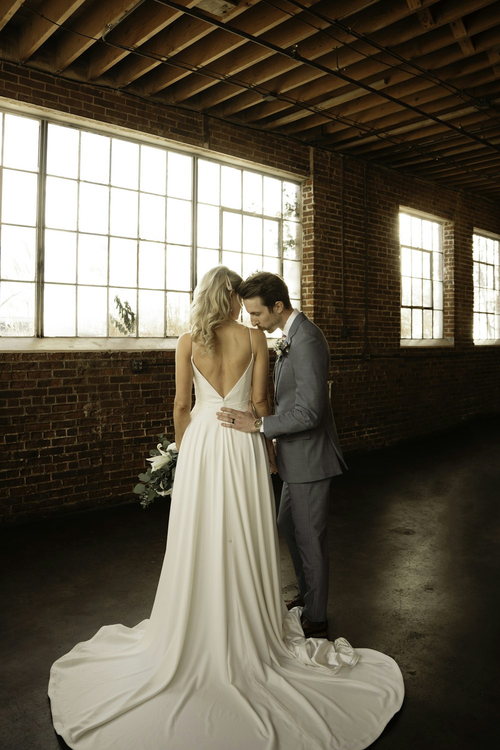 a bride and groom standing in an empty room