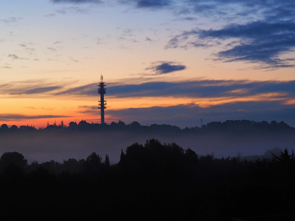 a very tall tower sitting in the middle of a forest