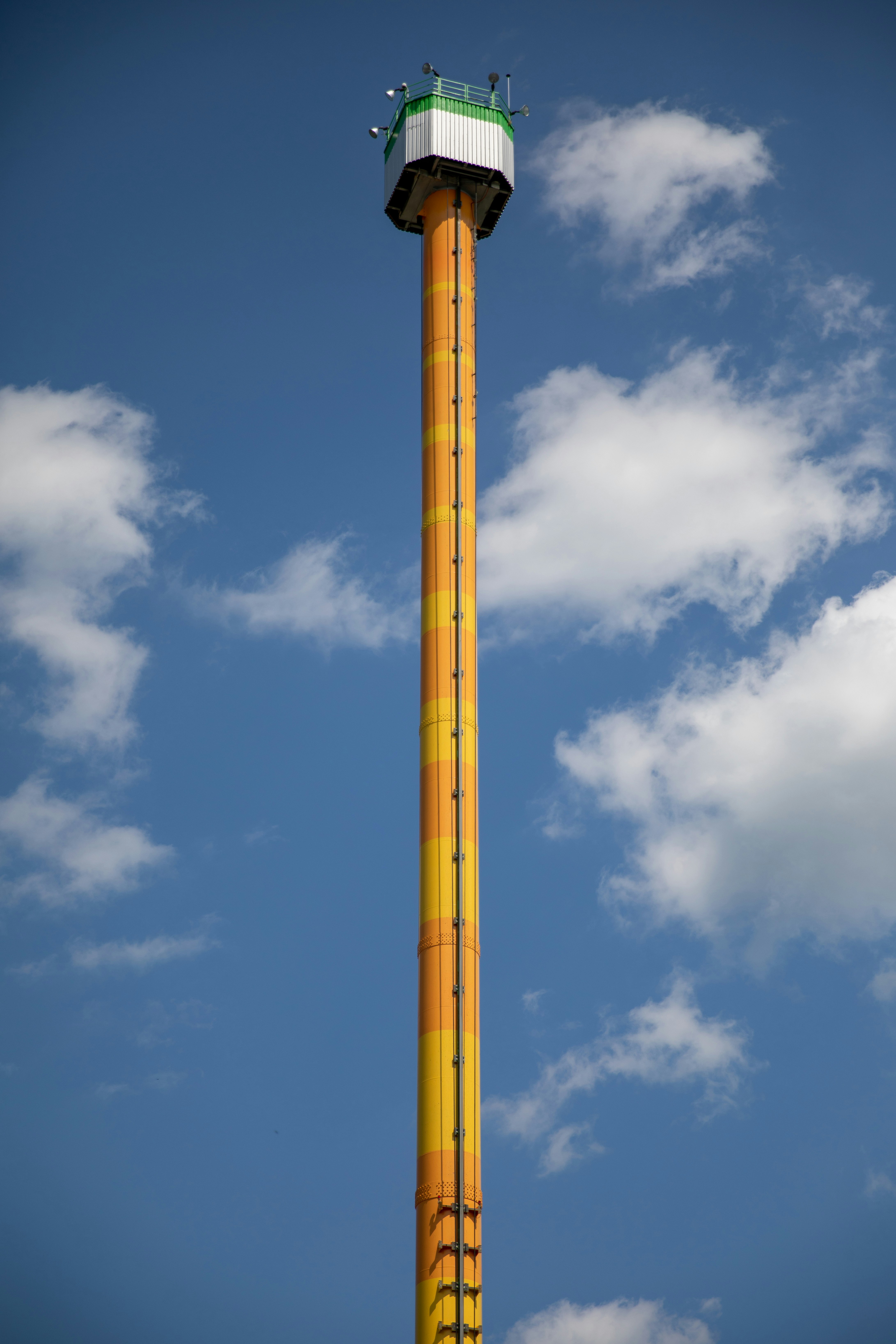 a tall yellow and green tower with a sky background