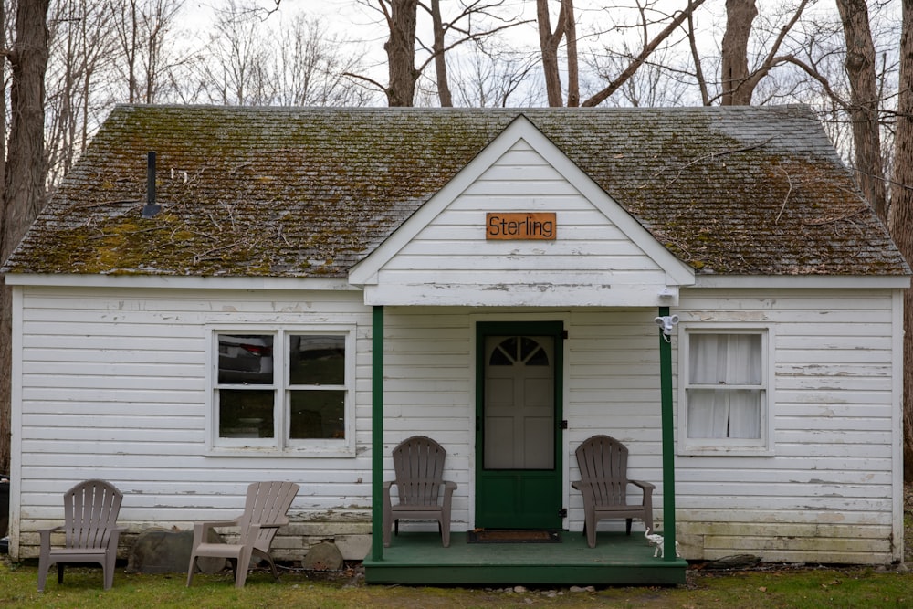 uma pequena casa branca com uma porta verde