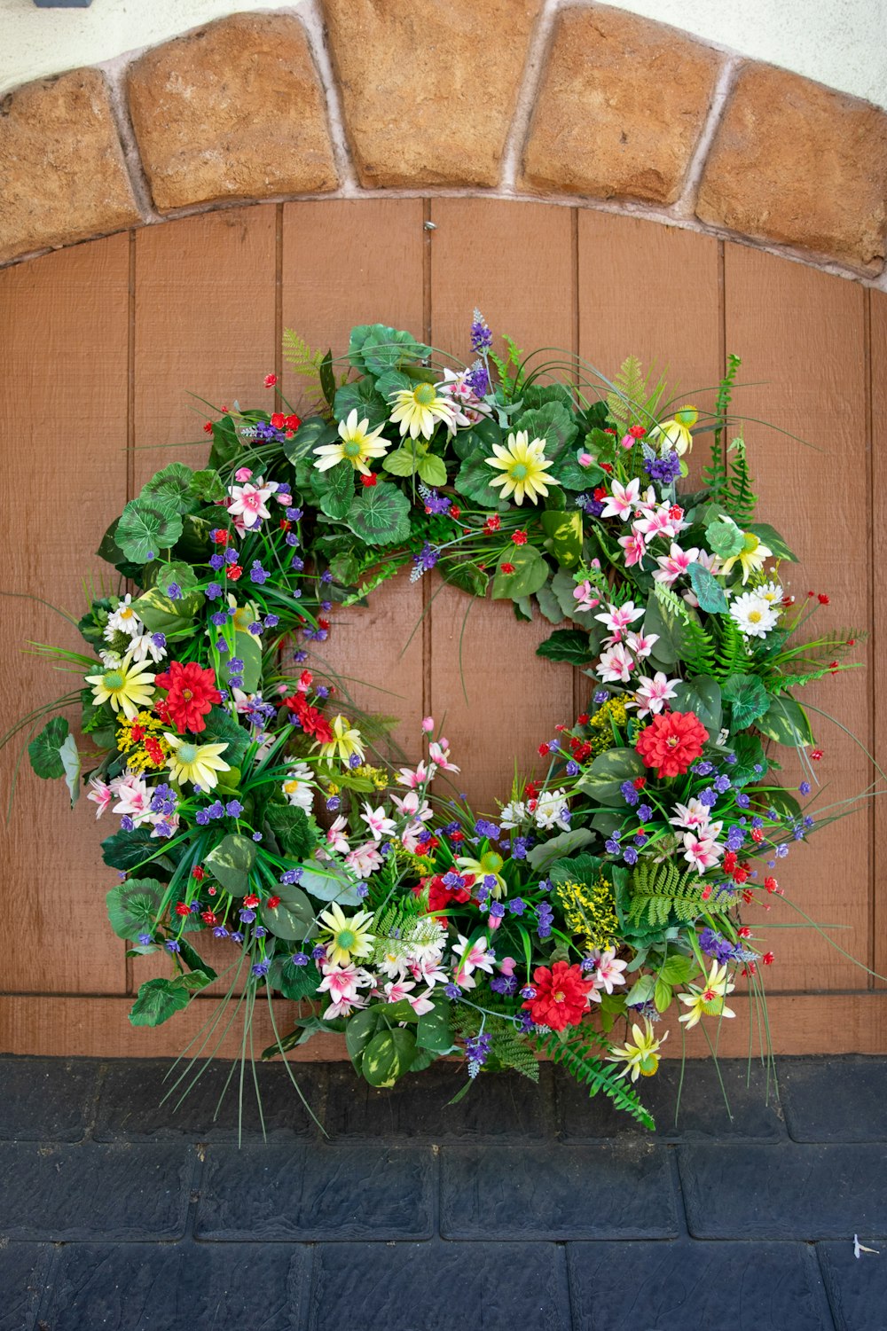 a wreath of flowers is hanging on a door