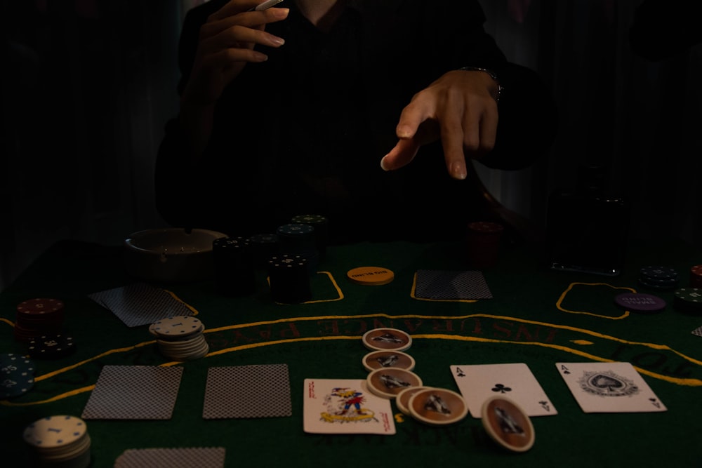 a person sitting at a table with cards and chips