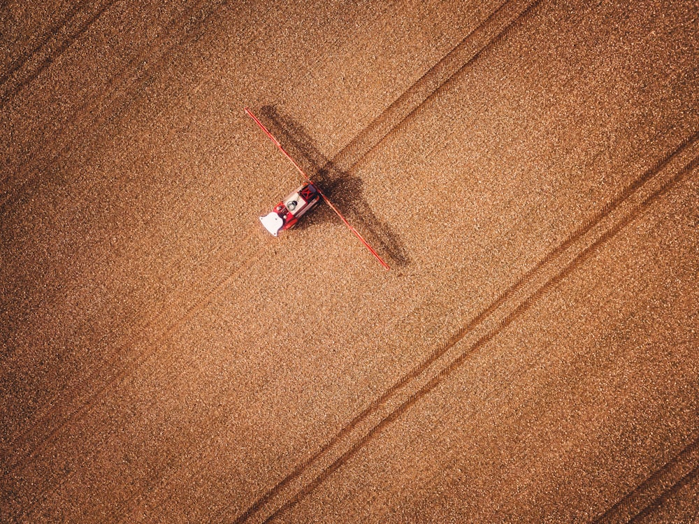 an aerial view of a red truck in a field