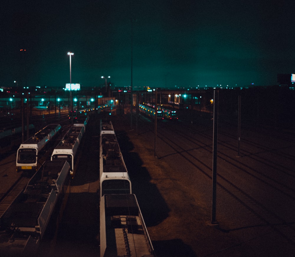 a train yard at night with trains on the tracks